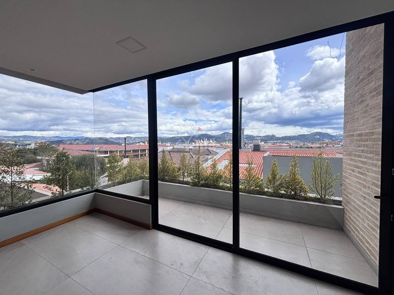 photo of a glazed corner opening onto a planted terrace with city views