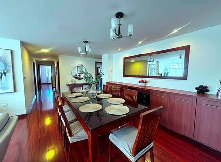 Dining room with dark wood table, six chairs, built-in cabinets, large mirror, recessed lighting, and hardwood floors.