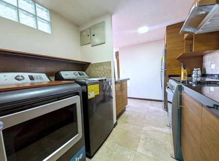 Kitchen with tile flooring, wooden cabinets, stainless steel appliances including double wall oven and gas range, and window with natural light above.