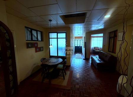 Interior hallway with cream walls, drop ceiling, game table, brown leather sofa, and multiple doorways with natural light.