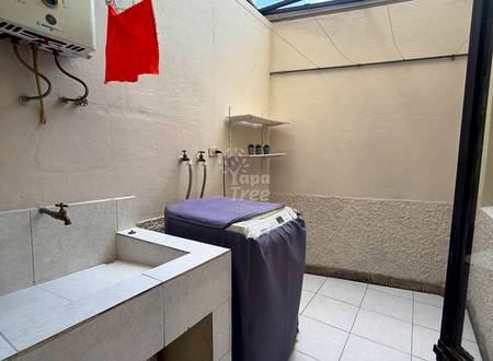 Bathroom with white tile floor, concrete sink basin, wall-mounted faucet, shelving, and washing machine under skylight.