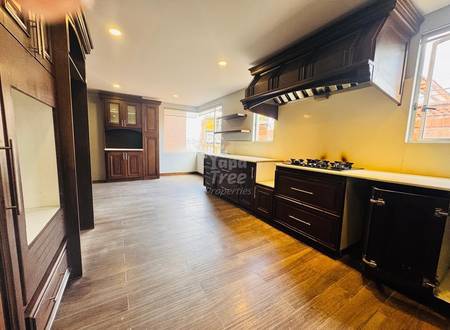 Kitchen with dark wood cabinetry, gas cooktop, yellow backsplash, recessed lighting, and tile flooring throughout the open layout.