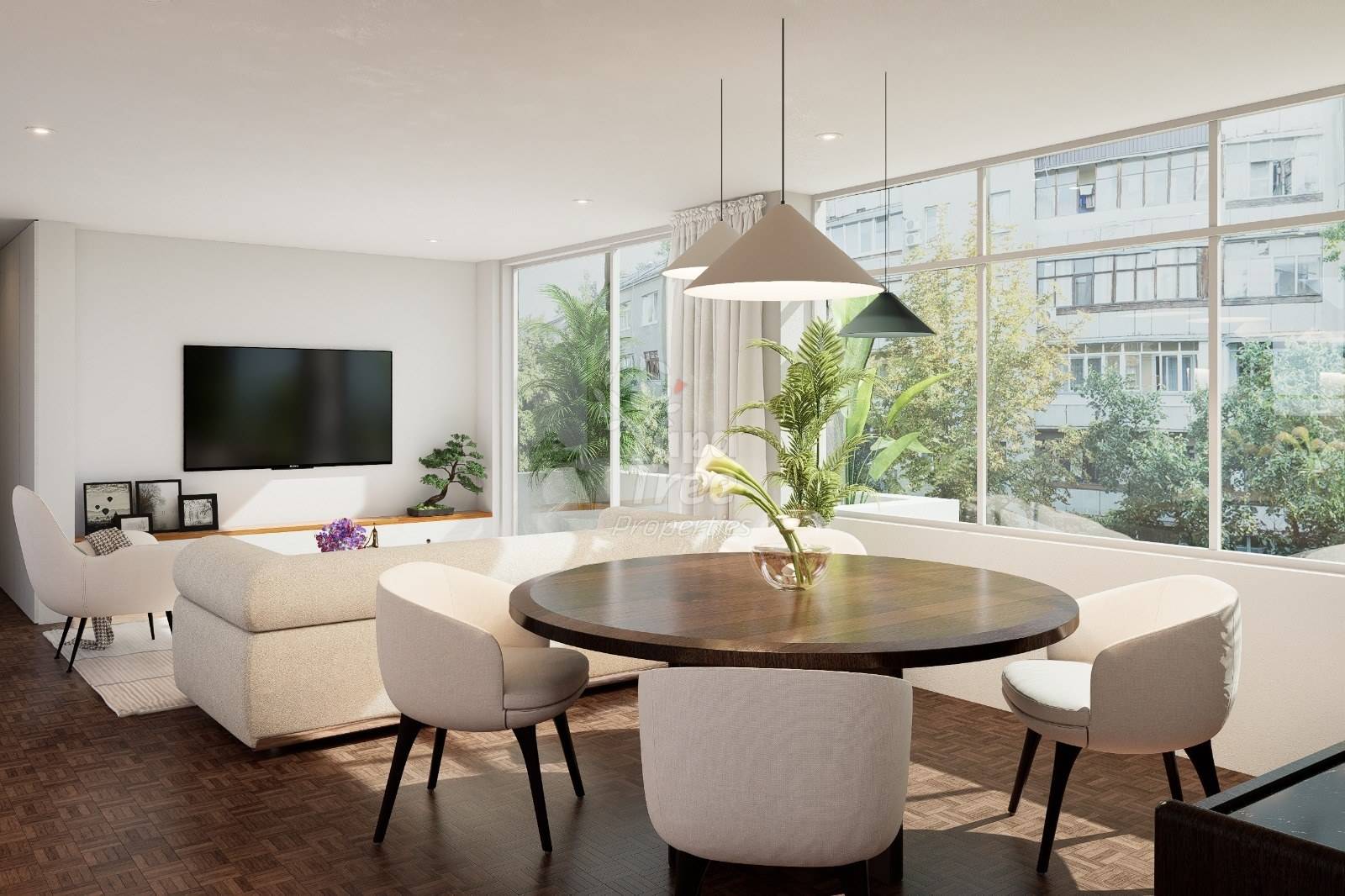 Modern living and dining area with cream furniture, round dark wood table, wall-mounted TV, pendant lights, and floor-to-ceiling windows overlooking city buildings.