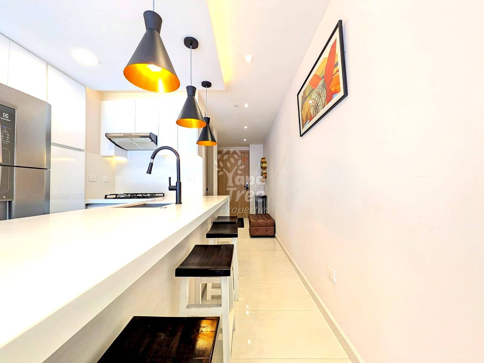 Modern cocina with white cabinetry, white quartz countertop, black pendant lights, stainless steel appliances, and black bar stools along island.