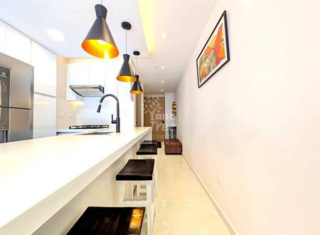 Modern cocina with white cabinetry, white quartz countertop, black pendant lights, stainless steel appliances, and black bar stools along island.