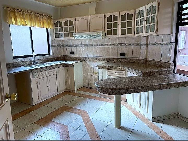 Kitchen with cream cabinets, granite countertops, tile backsplash, island with seating, and windows with natural light