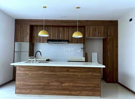 Kitchen with wood cabinets and island, granite countertop, two pendant lights, and tiled backsplash.