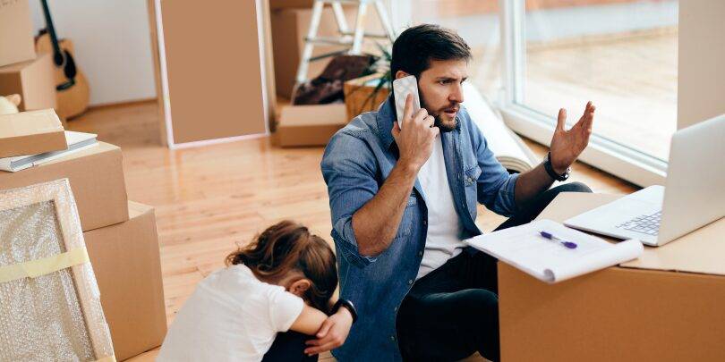 Displeased Father Using Laptop Talking Phone After Relocating Into New Home